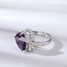 Adorn your finger with this ring and experience the epitome of luxury. The modern design of the bowknot gives a cute twist on a classic chic ring. Crafted in sterling silver, this ring features a purple pear-cut stone and a sparkling bowknot. The dazzling bowknot exudes elegance and cuteness. Impeccably suitable for women in love, you can wear it for your next date.Carat Weight: 4.72 ctStone Size: 8*11 mmStone Type: Jeulia® StoneNumber of Stones: 1 Stone Shape: PearStone Color: Amethyst PurpleCa Elegant Butterfly Ring With Cubic Zirconia For Gift, Elegant Butterfly Ring Cubic Zirconia Gift, Elegant Cubic Zirconia Butterfly Ring Gift, Elegant Infinity Ring As Gift, Elegant Round Butterfly Ring With Cubic Zirconia, Elegant Silver Butterfly Ring With Cubic Zirconia, Luxury Silver Jewelry With Bow Detail, Luxury Silver Jewelry With Bow, Elegant Cubic Zirconia Butterfly Ring For Anniversary