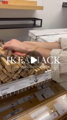 a person laying on top of a pile of wooden planks in a store display