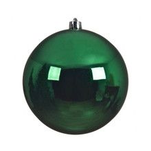 a shiny green ornament hanging on a white wall