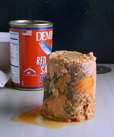 a can of red sea next to a piece of food