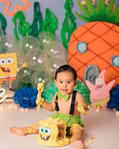 a little boy sitting on the floor in front of some decorations