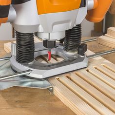 a close up of a driller on a table with wood planks and nails