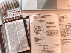 an open book sitting on top of a desk next to some markers and pencils