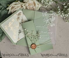 wedding stationery with flowers and greenery displayed on table