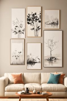 a living room with white couches and paintings on the wall above them, along with coffee table