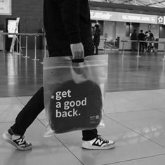 black and white photo of person carrying bag with slogan'get a good back '