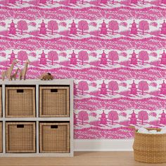 a pink and white wallpaper with trees in the background is next to a wicker basket