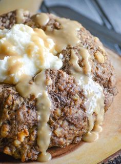 a close up of food on a cutting board with gravy and mashed potatoes