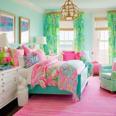 a bedroom decorated in bright colors with pink, blue and green accessories on the bed