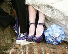 the bride and groom's shoes are next to their bouquet