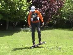 a man riding a skateboard across a lush green field