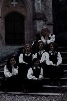 a group of young people sitting on the steps in front of a building