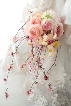 a bridal holding a bouquet of pink and yellow flowers