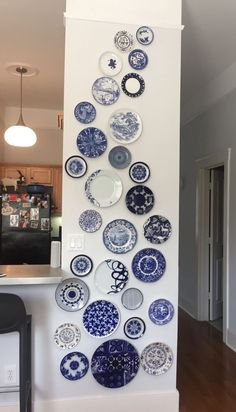 a wall mounted with plates on it in a kitchen