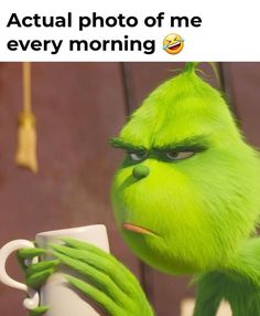 the grin face is holding a coffee cup and looking at it with caption that reads, actual photo of me every morning