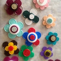 there are many different colored flower buttons on the counter top, and one has a button that says i love you