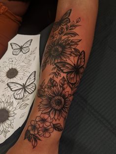 a woman's arm with flowers and butterflies on it