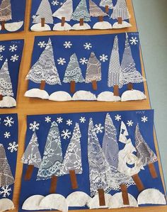 four pieces of paper cut out to look like christmas trees with snowflakes on them