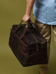 Here is the perfect blend of sophistication and style with our unique leather duffle bag in a rich, textured coffee bean hue, accented by sleek black handles. The full-grain buffalo leather adds to the endurance yes well as the charm of the duffle bag. Best for short trips and routine journeys. Elevate your travel game with this distinctive accessory today! Salient Features Made of grain buffalo leather Pure brass hardware with bottom studs to protect the bag Adjustable leather shoulder strap with padding Consists of a large central compartment with one front zipped pocket for easy access. Can be used as a carry-on bag on airplanes Size Available 20 L x 9 H x 8 W Inches / 48.26 L x 22.86 H x 20.32 W Cms Brown Satchel With Luggage Sleeve For Travel, Everyday Brown Travel Bag With Luggage Sleeve, Travel Satchel With Oiled Leather And Leather Lining, Oiled Leather Satchel For Travel, Brown Oiled Leather Duffle Bag For Travel, Brown Satchel Luggage For Travel, Classic Brown Duffle Bag For Daily Use, Brown Classic Duffle Bag For Daily Use, Brown Oiled Leather Rectangular Travel Bag