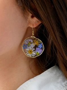 Large wildflower resin earrings pressed purple yellow wildflowers gold plated handmade, epoxy resin, colorful flower earrings, blossom earrings Large round handmade earrings with real, pressed purple meadowfoam, yellow rocket flowers and blue forget-me-nots in crystal-clear synthetic resin / resin / epoxy resin, set in a round, organically shaped setting made of gold brass * Each piece is handmade - the flowers are wildflowers, picked locally and pressed by hand. They are then cast in several la Summer Gold Resin Earrings, Spring Flower Shaped Jewelry With Pressed Flowers, Spring Flower Jewelry With Pressed Flowers, Summer Pressed Flowers Jewelry Gift, Summer Gift Jewelry With Pressed Flowers, Gold Birth Flower Jewelry For Summer, Gold Floral Print Flower Earrings, Summer Pressed Flower Jewelry, Summer Flower Shaped Pressed Flower Jewelry