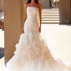 a woman in a white wedding dress posing for the camera