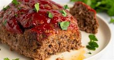 meatloaf with ketchup and garnish on a white plate next to parsley