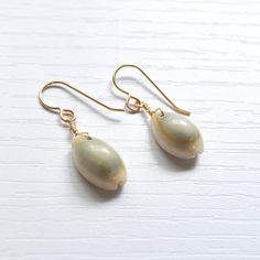 Simple & cute describe these whole cowrie shell earrings! They're the perfect accessory to wear with your favorite casual outfit when you're out & about. Please allow for variations in size and shape of shells as each is unique. Cowrie Shell Dangle Earrings As Gift, Cowrie Shell Earrings For Gifts, Casual Cowrie Shell-shaped Jewelry, Summer Shell-shaped Earrings With Ear Wire, Casual Drop Earrings For Beach, Casual Drop Earrings For Vacation, Casual Beach Earrings, Shell-shaped Earrings With Ear Wire, Gold Cowrie Shell Earrings As Gift