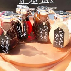 there are four different types of condiments on the table with tags attached to them