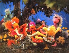 the muppets are sitting on top of each other in front of a tree