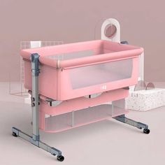 a pink baby crib sitting on top of a table