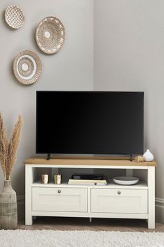 a flat screen tv sitting on top of a wooden entertainment center in a living room