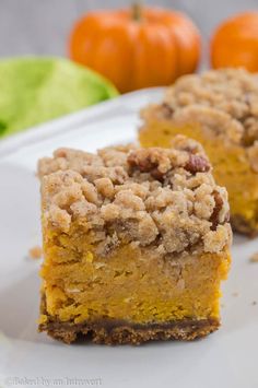 two pieces of pumpkin crumb cake on a white plate next to some oranges