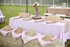 a table topped with hay bales covered in hats