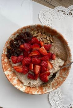 a bowl filled with oatmeal and strawberries on top of a table