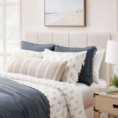 a bed with blue and white comforters in a bedroom