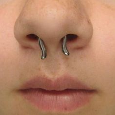 a close up of a person with two nose rings attached to their nose and the other end of his nose