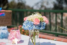 a vase filled with pink and blue flowers on top of a table