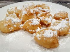 powdered sugar covered pastries on a white plate