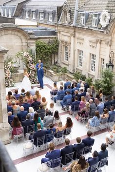 a man and woman are standing in front of an audience at a wedding ceremony outside