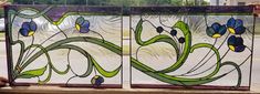 two stained glass panels sitting on top of a window sill next to each other