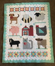 a quilted wall hanging with farm animals on it