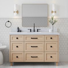 a bathroom vanity with two sinks and a large mirror over the top that hangs above it