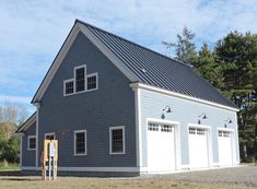 a two car garage with three windows on the front and one door open to let in lots of light