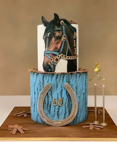 a birthday cake with a horse head on top and a horseshoe shaped candle holder in the middle