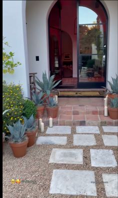 the front entrance to a house with potted plants