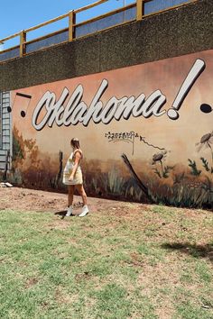 a woman walking past a mural on the side of a building