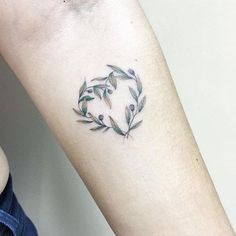 a woman's arm with a small tattoo design on the left side of her arm