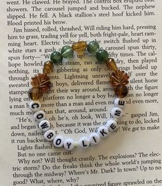 a beaded bracelet with words written in white and green beads on top of an open book