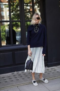 Blogger Camille Over the Rainbow wears a sweater, statement necklace, pleated midi skirt, sneakers, and a top-handle clutch Casual Chique Stijl, Rok Midi, Rok Outfit, Eleanor Calder, Fish Stock, Rock Outfit, It Bag, Smart Outfit, Transition Outfits