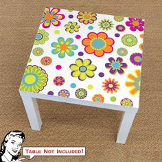 a white table with colorful flowers on it and a cartoon character next to it that says,'table not included '